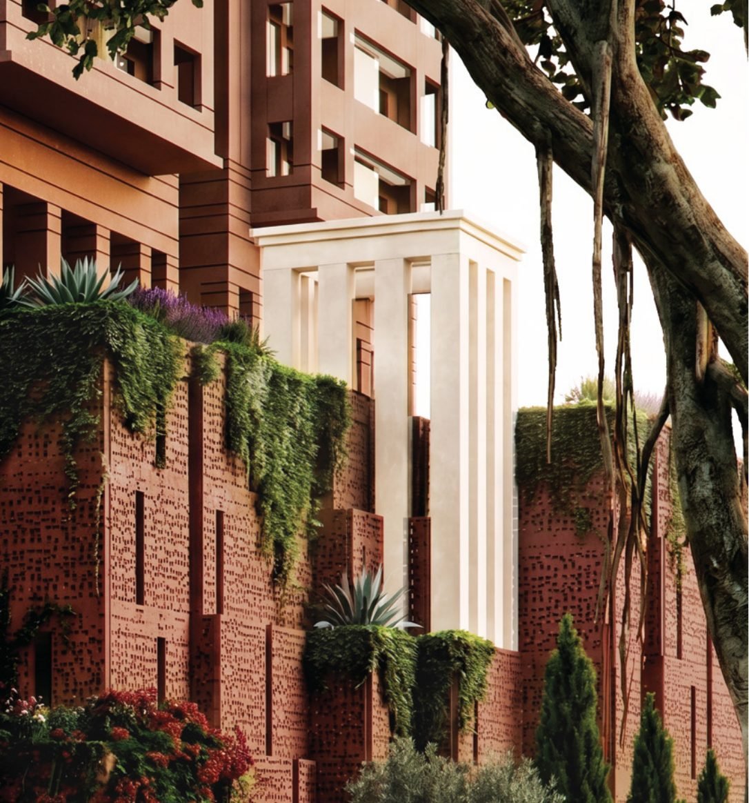 Brigade Barcelona façade detail — terracotta-red perforated podium walls, cascading planting and a cream colonnade